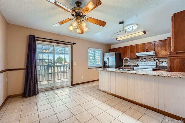 kitchen featuring stainless steel fridge with ice dispenser, white electric range, a textured ceiling, and under cabinet range hood