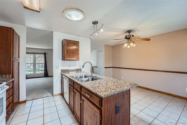 kitchen with a peninsula, ceiling fan, a textured ceiling, a sink, and light tile patterned floors