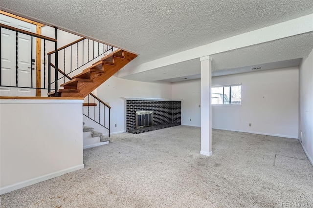 basement featuring stairs, a brick fireplace, baseboards, a textured ceiling, and carpet flooring