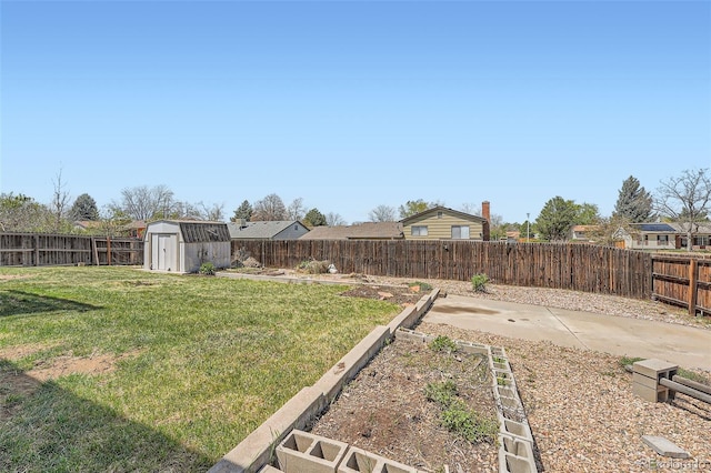 view of yard featuring a storage shed, an outbuilding, a fenced backyard, and a vegetable garden