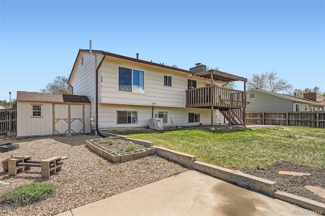rear view of house with a fenced backyard, a storage unit, stairs, and a yard