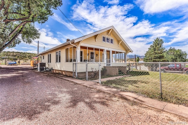 view of front of house featuring central AC, covered porch, and a front lawn