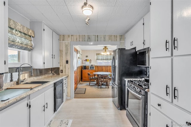 kitchen with white cabinetry, sink, stainless steel appliances, and light carpet