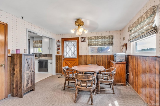 carpeted dining area with wooden walls and sink