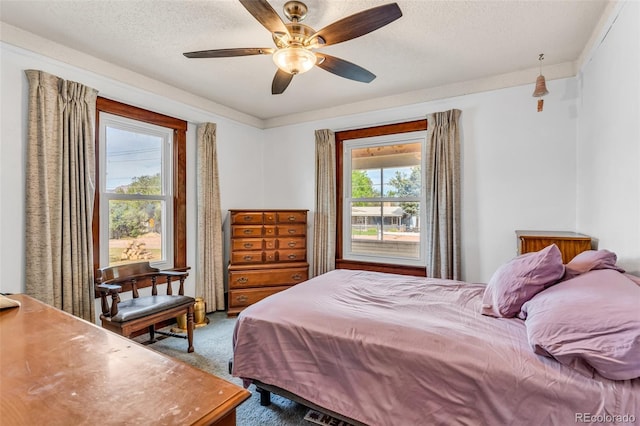 bedroom with carpet, ceiling fan, ornamental molding, and a textured ceiling