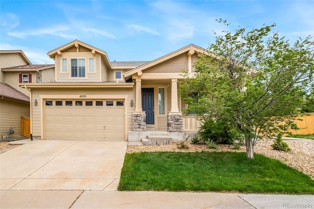 craftsman house featuring covered porch, driveway, a garage, and stone siding