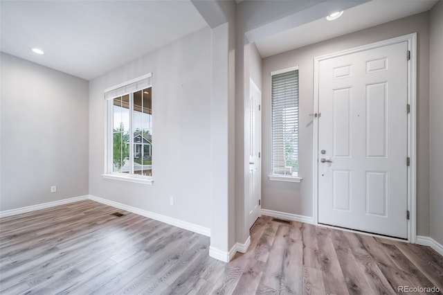 foyer with wood finished floors, baseboards, and recessed lighting