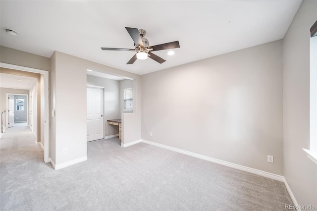 unfurnished bedroom featuring light colored carpet, baseboards, and multiple windows