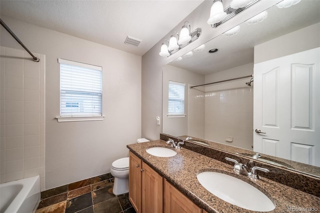 full bathroom with plenty of natural light, toilet, tub / shower combination, and double vanity