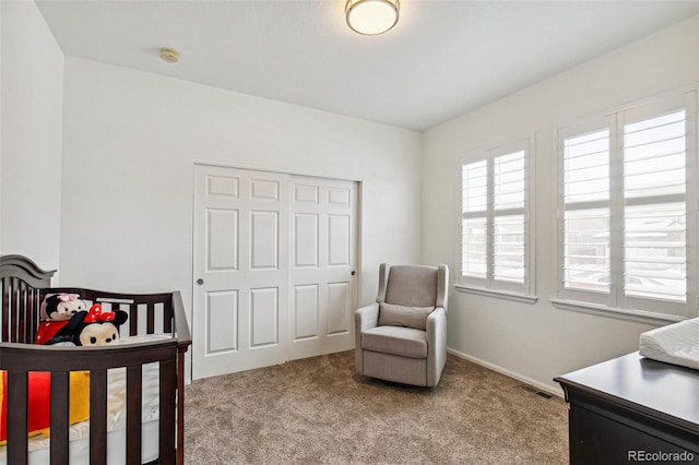 bedroom with light carpet, a closet, and a nursery area