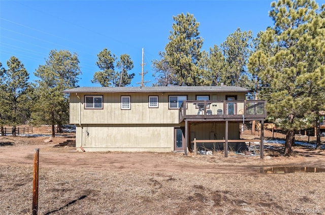 rear view of house featuring a wooden deck