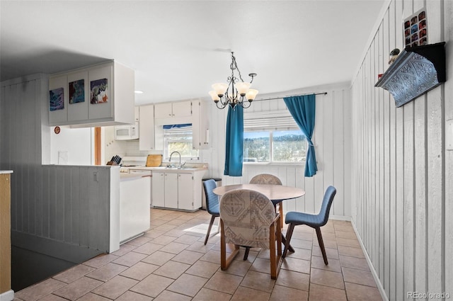 dining room with light tile patterned floors and a chandelier