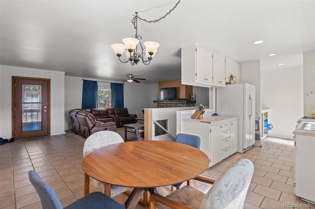 dining room with light tile patterned floors and ceiling fan with notable chandelier