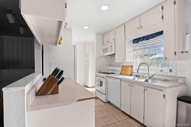 kitchen with white appliances, tasteful backsplash, light countertops, a sink, and recessed lighting