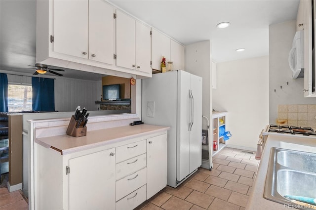 kitchen with light countertops, a ceiling fan, white cabinetry, a sink, and white appliances