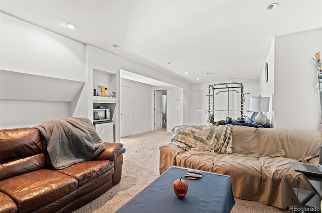 living room with recessed lighting, built in shelves, and light colored carpet