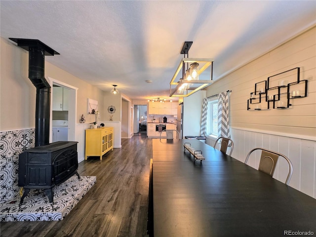 313 W Arkansas St, Buena Vista, CO 81211 - dining room featuring dark wood-type flooring, a wood stove, and washer / dryer
