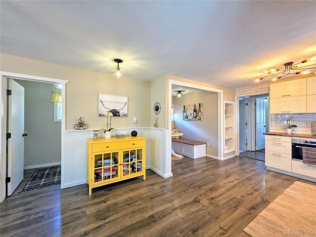 313 W Arkansas St, Buena Vista, CO 81211 - kitchen featuring stainless steel oven, dark wood-style flooring, a wainscoted wall, and butcher block counters