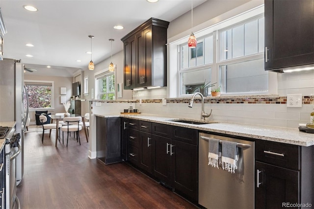 815 S Gaylord St, Denver, CO 80209 - kitchen with stainless steel appliances, dark wood-style flooring, tasteful backsplash, light stone counters, and recessed lighting