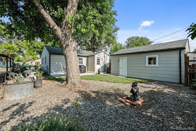 5465 Saulsbury Ct, Arvada, CO 80002 - rear view of house featuring an outbuilding and a shingled roof
