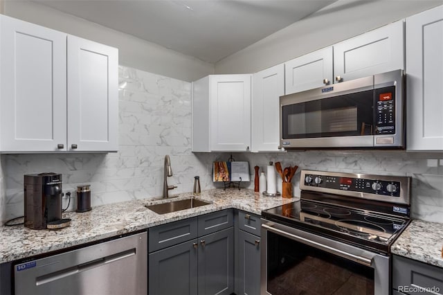 kitchen with gray cabinets, backsplash, sink, white cabinetry, and appliances with stainless steel finishes