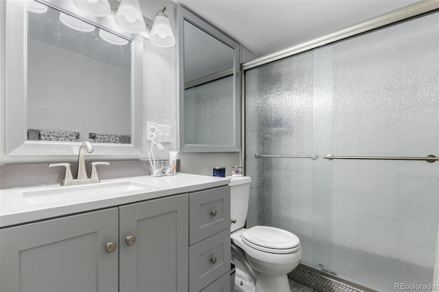 bathroom with a shower with door, toilet, and large vanity