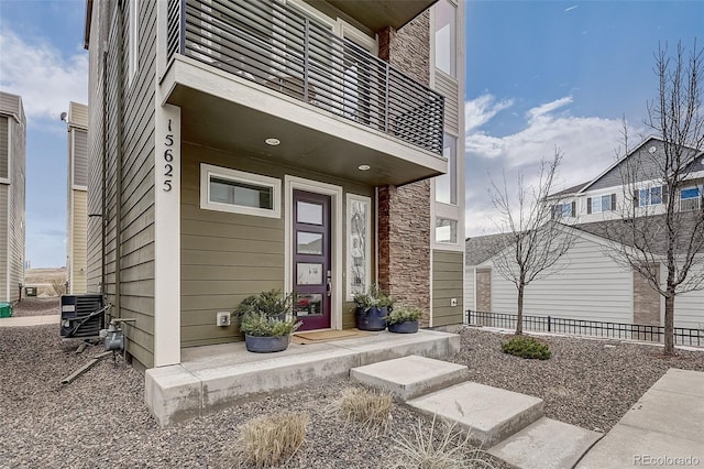 property entrance featuring a balcony and central air condition unit