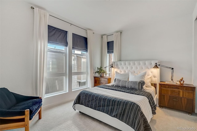 bedroom featuring light colored carpet and multiple windows