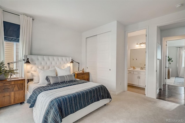 carpeted bedroom featuring ensuite bathroom and a closet