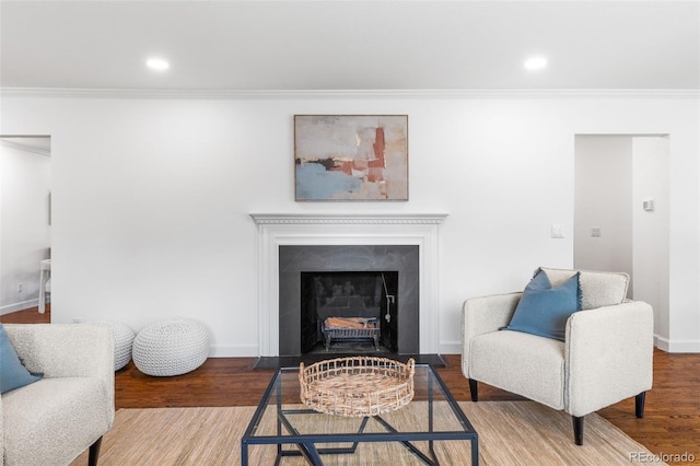 living area with hardwood / wood-style floors and crown molding