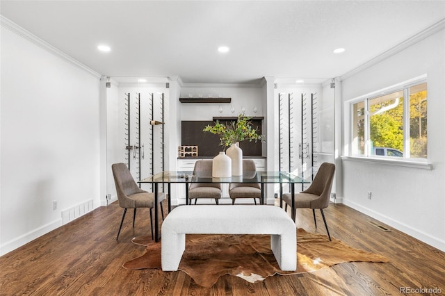 dining space with crown molding and hardwood / wood-style floors