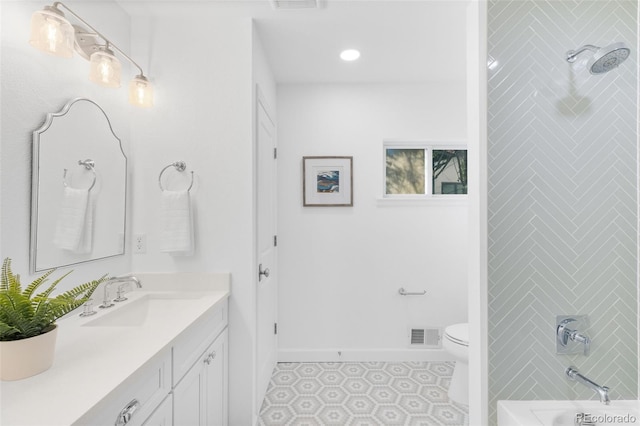 full bathroom featuring tiled shower / bath, vanity, toilet, and tile patterned floors