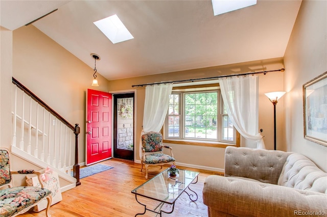 6687 Devinney Ct, Arvada, CO 80004 - living area with a skylight, wood finished floors, stairs, baseboards, and high vaulted ceiling