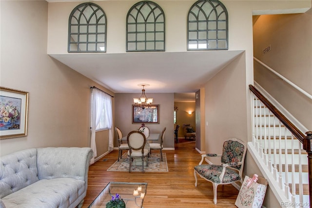 6687 Devinney Ct, Arvada, CO 80004 - living area with a chandelier, wood finished floors, stairway, a high ceiling, and baseboards