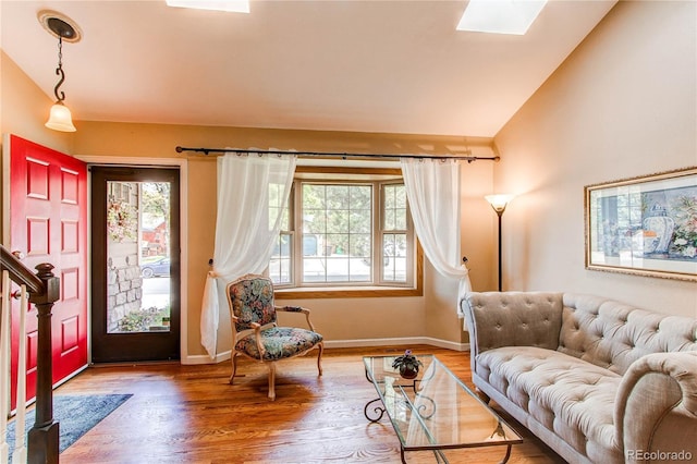 6687 Devinney Ct, Arvada, CO 80004 - living area with lofted ceiling, wood finished floors, a skylight, and baseboards