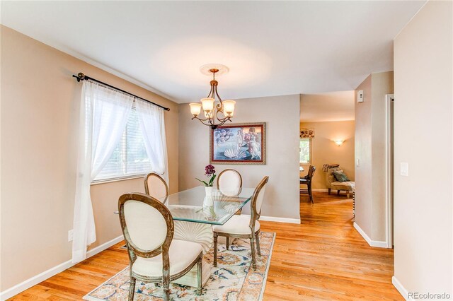 6687 Devinney Ct, Arvada, CO 80004 - dining room with light wood-type flooring, a chandelier, and baseboards