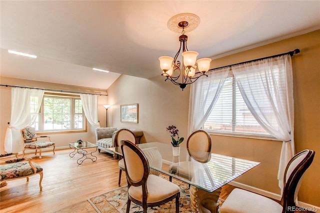 6687 Devinney Ct, Arvada, CO 80004 - dining space with a chandelier, wood finished floors, lofted ceiling, and baseboards