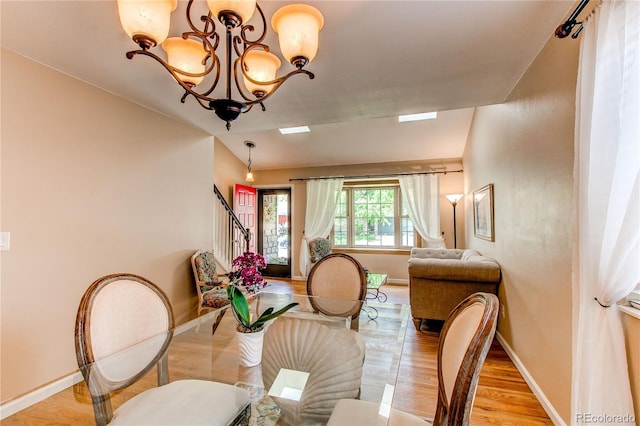 6687 Devinney Ct, Arvada, CO 80004 - dining area with a chandelier, baseboards, stairway, and light wood-style flooring