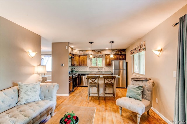 6687 Devinney Ct, Arvada, CO 80004 - living area featuring light wood-style flooring, healthy amount of natural light, and baseboards