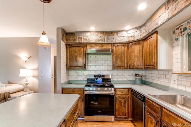 6687 Devinney Ct, Arvada, CO 80004 - kitchen with appliances with stainless steel finishes, wall chimney range hood, backsplash, and light countertops