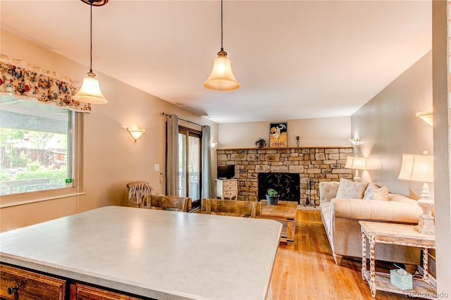 6687 Devinney Ct, Arvada, CO 80004 - kitchen featuring light wood finished floors, pendant lighting, and a fireplace