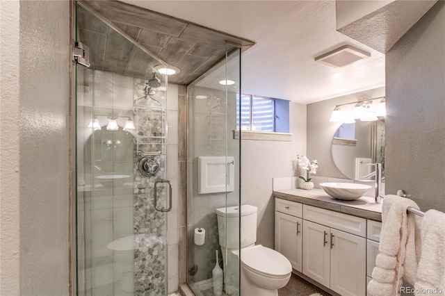 6687 Devinney Ct, Arvada, CO 80004 - full bathroom featuring toilet, vanity, a shower stall, and a textured wall