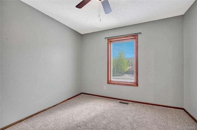 carpeted spare room featuring ceiling fan and a textured ceiling