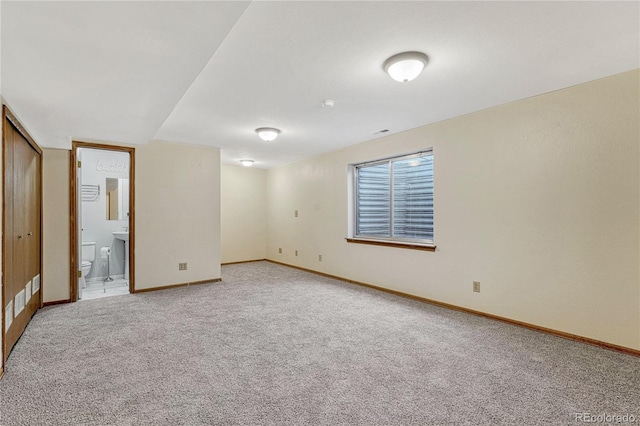 unfurnished bedroom featuring ensuite bathroom, a closet, and carpet