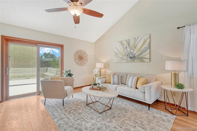 living room featuring ceiling fan, hardwood / wood-style floors, and vaulted ceiling