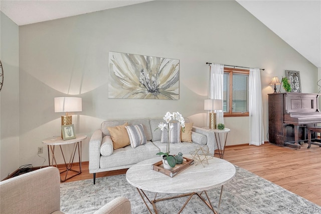 living room with light wood-type flooring and vaulted ceiling