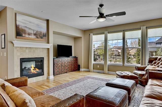 living room with ceiling fan, wood-type flooring, and a fireplace