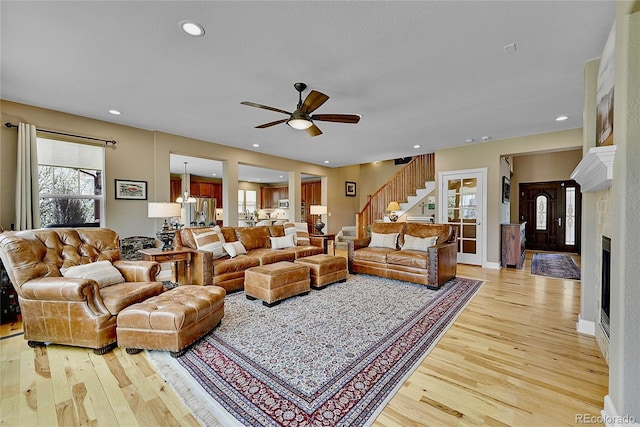 living room with light hardwood / wood-style flooring and ceiling fan