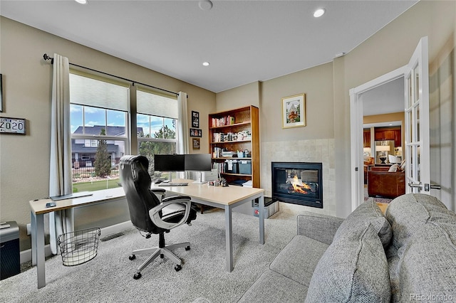 office featuring light colored carpet and a fireplace