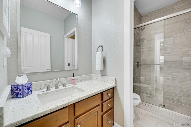 bathroom with vanity, toilet, and an enclosed shower